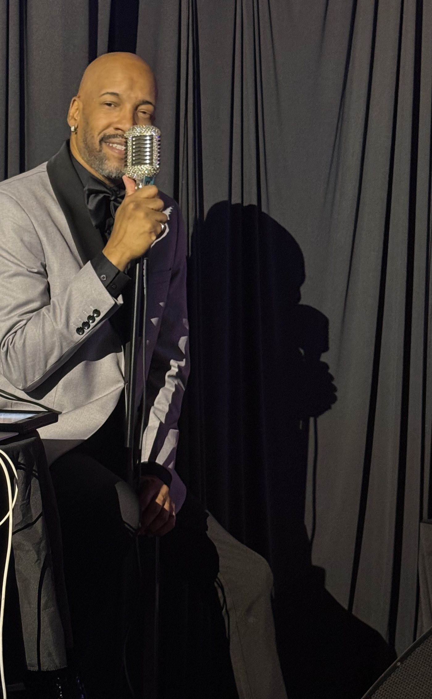 Antonio singing into a vintage microphone at Tap That